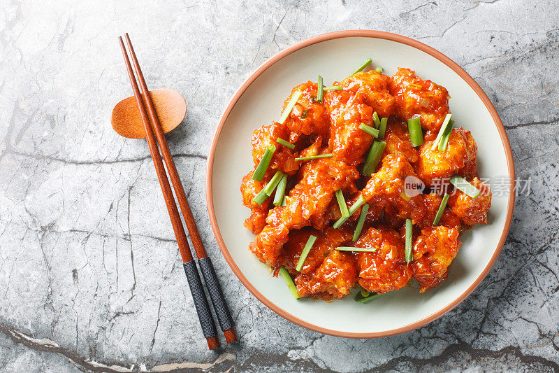 Gobi manchurian is a traditional Indo-Chinese dish consisting of fried cauliflower that’s tossed in a sweet and spicy sauce closeup on the plate. Horizontal top viewGobi manchurian is a traditional Indo-Chinese dish consisting of fried cauliflower that�